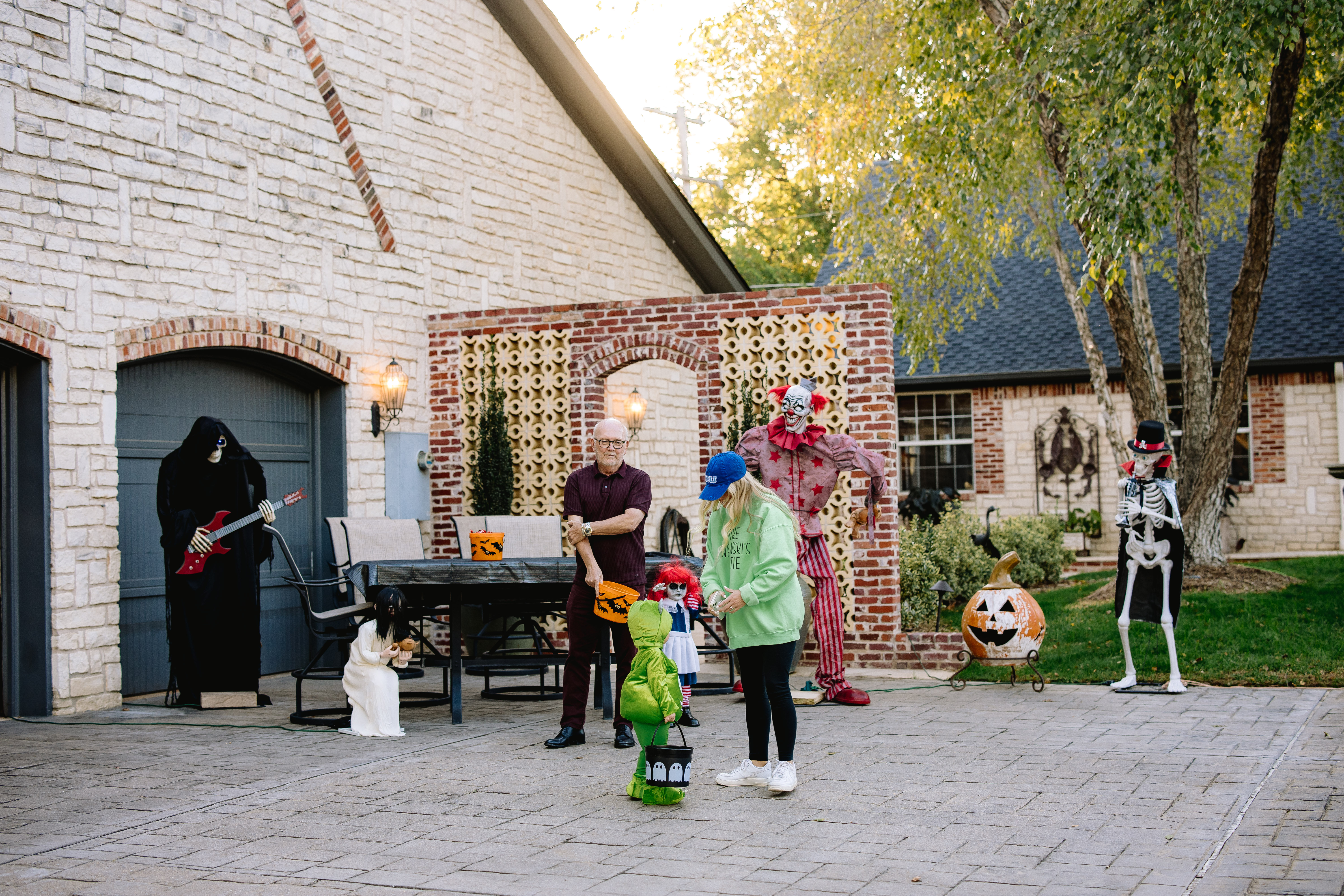 Trick-or-treaters visiting a decorated home at the Prestonwood Halloween Walk